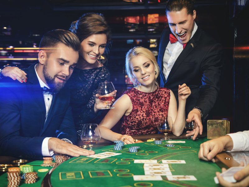 four people playing blackjack and smiling
