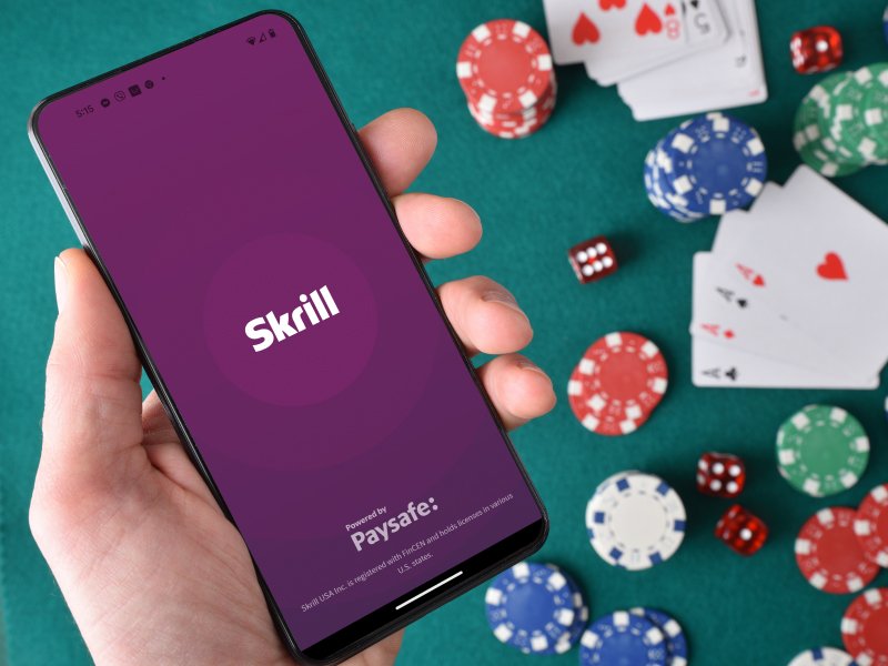 hand holding mobile phone with Skrill app open