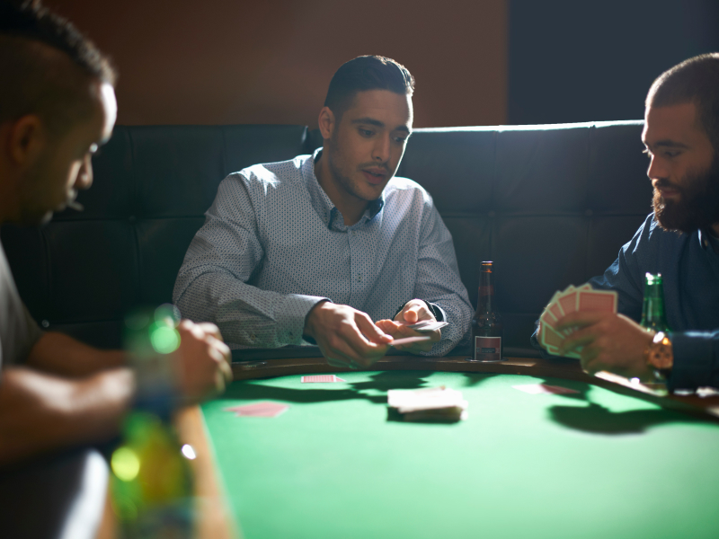 three men playing poker