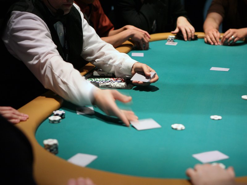 poker table with dealer giving out cards